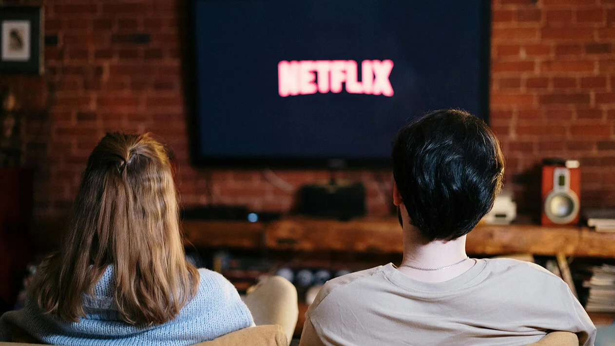 People Sitting on a Couch Watching Netflix